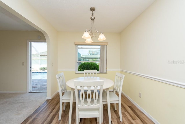 dining space with a notable chandelier and hardwood / wood-style floors