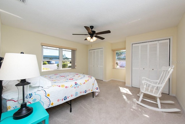 bedroom with ceiling fan, a textured ceiling, and light colored carpet