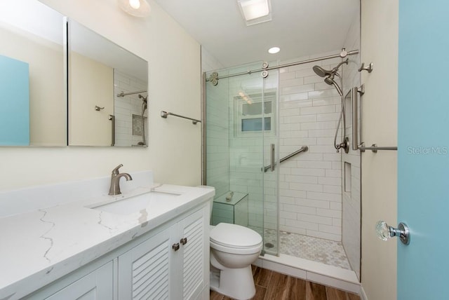 bathroom with vanity, hardwood / wood-style flooring, toilet, and an enclosed shower