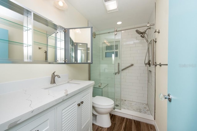 bathroom featuring vanity, toilet, hardwood / wood-style flooring, and walk in shower