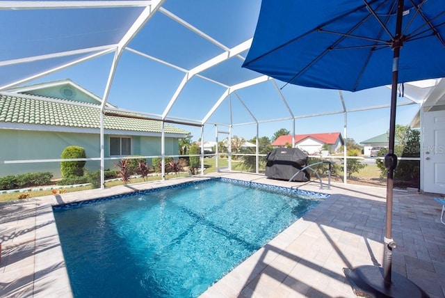 view of swimming pool featuring area for grilling, a patio, and a lanai