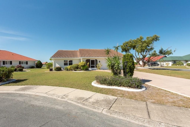 mediterranean / spanish home with a front lawn