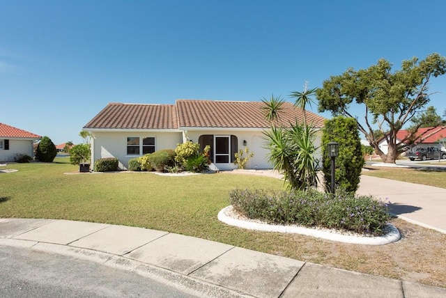 mediterranean / spanish house featuring a front lawn