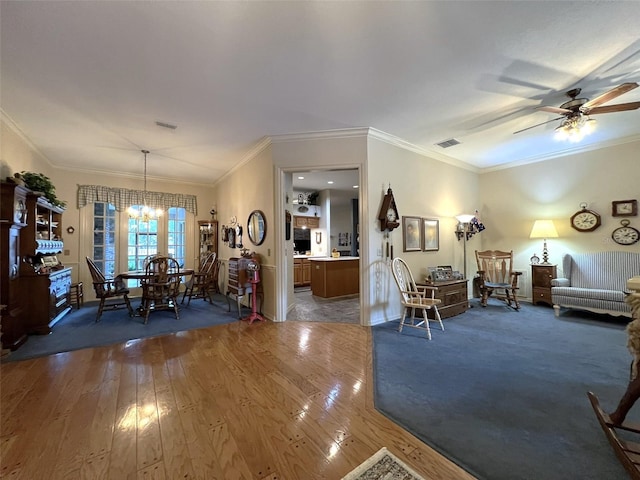 living room featuring crown molding, ceiling fan with notable chandelier, and dark hardwood / wood-style flooring