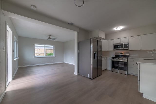 kitchen with ceiling fan, light hardwood / wood-style floors, white cabinetry, and appliances with stainless steel finishes