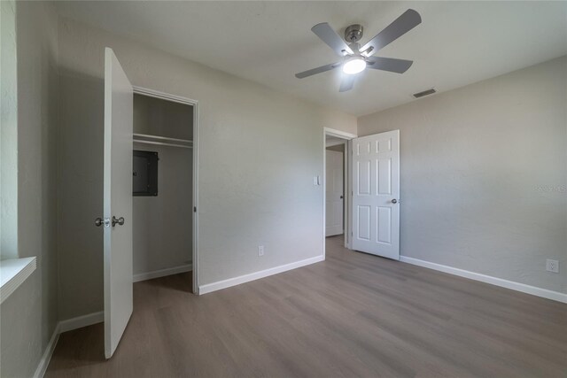 1328 Barry St, Clearwater, FL 33756 - unfurnished bedroom with electric panel, wood finished floors, baseboards, a closet, and a ceiling fan