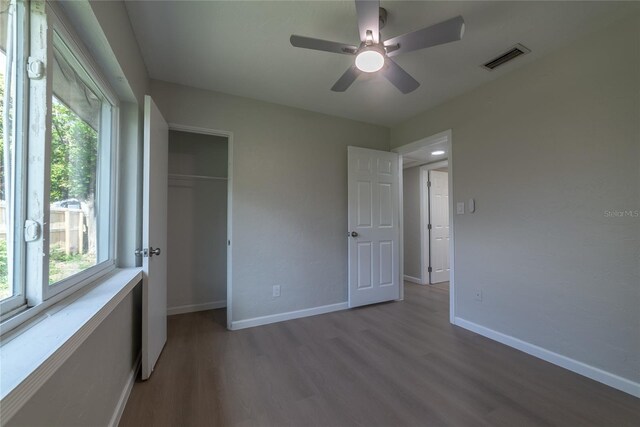 1328 Barry St, Clearwater, FL 33756 - unfurnished bedroom with wood finished floors, a closet, baseboards, and a ceiling fan