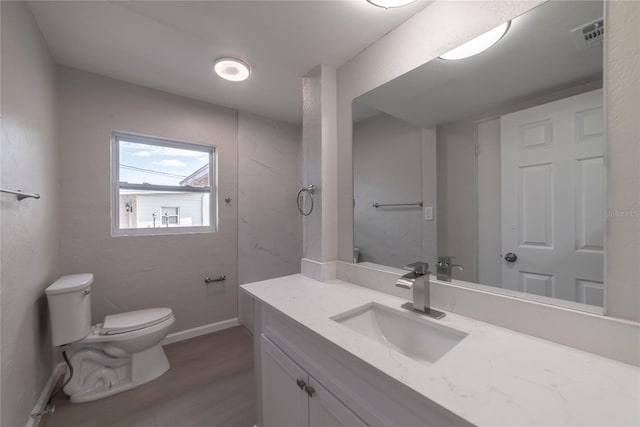 bathroom with vanity, wood-type flooring, and toilet