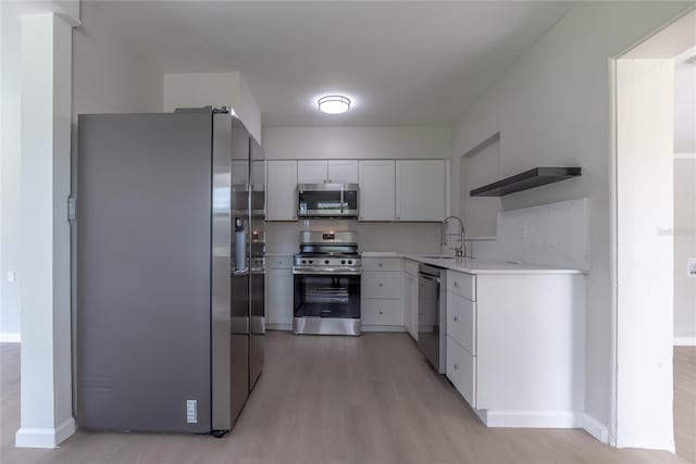 kitchen with sink, white cabinets, stainless steel appliances, and light wood-type flooring