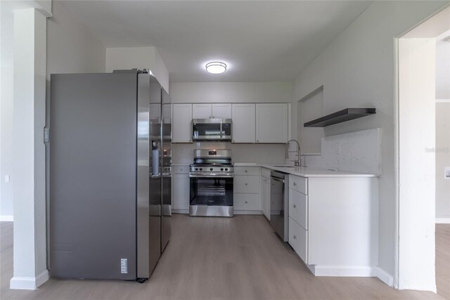 1328 Barry St, Clearwater, FL 33756 - kitchen with stainless steel appliances, a sink, light wood-style flooring, open shelves, and light countertops