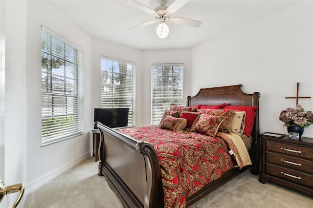 bedroom featuring light carpet, multiple windows, and ceiling fan