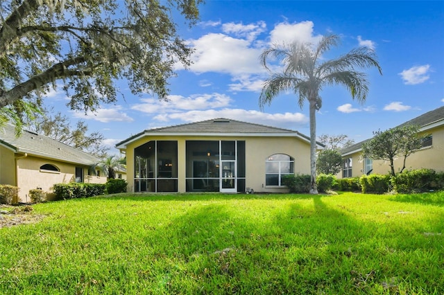 rear view of property featuring a lawn and a sunroom