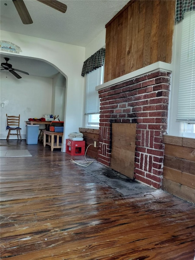 living room featuring dark wood-type flooring, a fireplace, and a textured ceiling