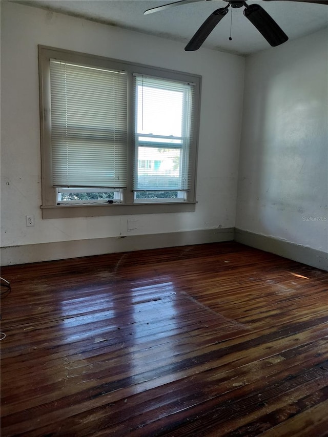 empty room featuring dark wood-type flooring and ceiling fan