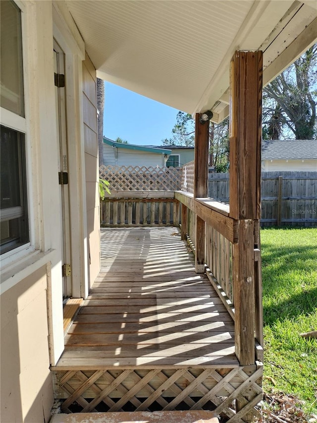 wooden deck featuring a lawn