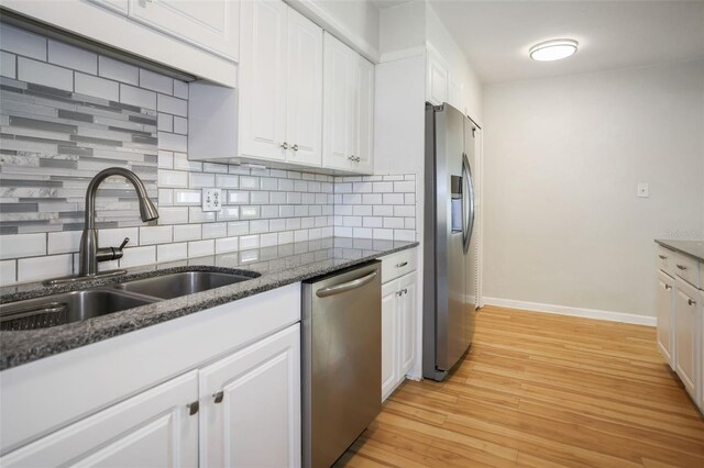 kitchen with appliances with stainless steel finishes, decorative backsplash, and white cabinetry