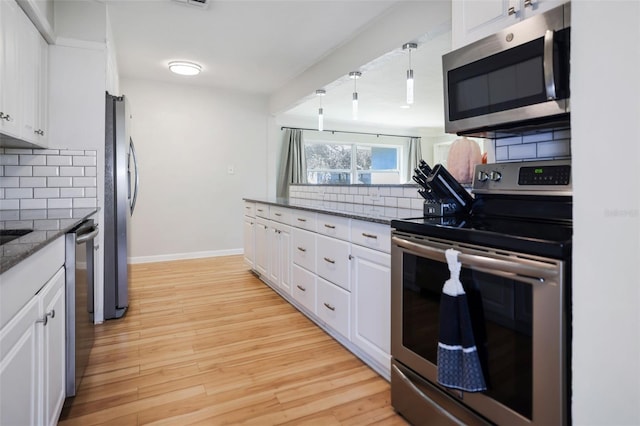 kitchen with white cabinetry, tasteful backsplash, appliances with stainless steel finishes, and light hardwood / wood-style flooring