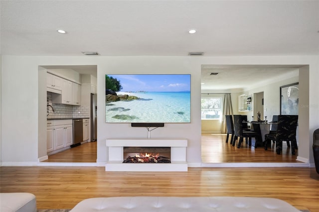 living room featuring sink and light hardwood / wood-style floors