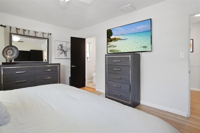 bedroom featuring light hardwood / wood-style floors, ensuite bath, and ceiling fan