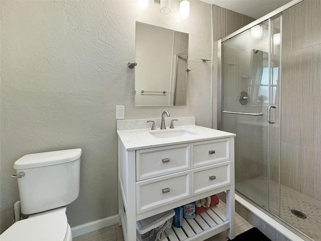 bathroom with vanity, toilet, and a shower with shower door