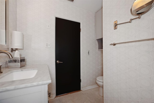 bathroom with toilet, vanity, and tile patterned flooring