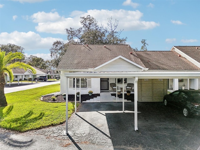 back of house with a lawn and a carport