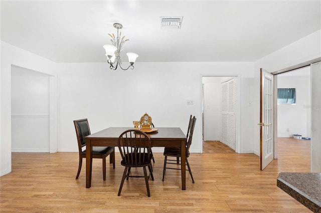 dining room featuring light wood-type flooring and a chandelier