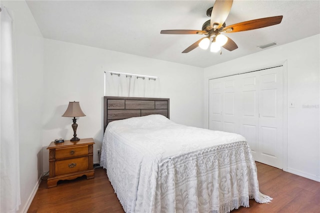 bedroom featuring dark wood-type flooring, ceiling fan, and a closet