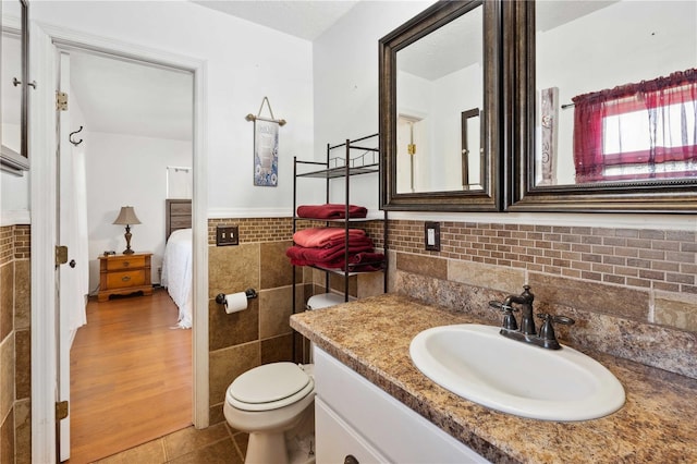 bathroom featuring tile walls, tile patterned flooring, vanity, and toilet