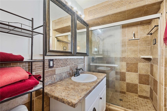 bathroom with walk in shower, vanity, and backsplash