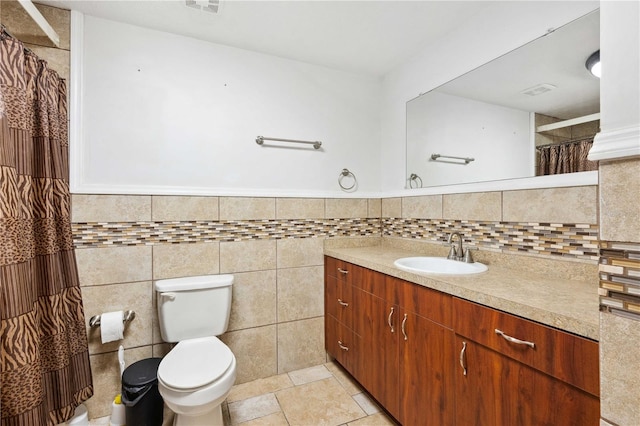 bathroom with tile walls, vanity, tile patterned floors, and toilet