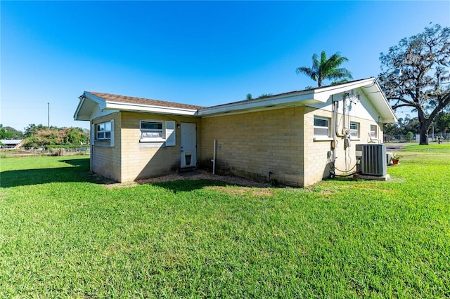 view of property exterior featuring central AC and a yard