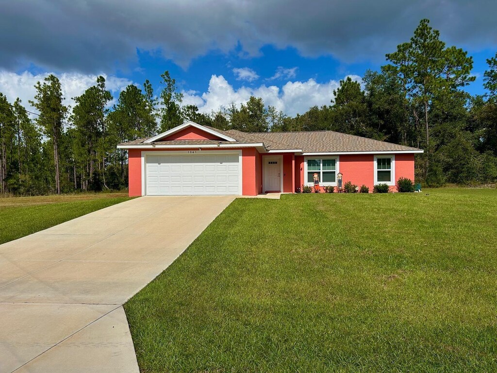 1541 W G Martinelli Blvd, Citrus Springs, FL 34434 - ranch-style home featuring an attached garage, driveway, and a front yard