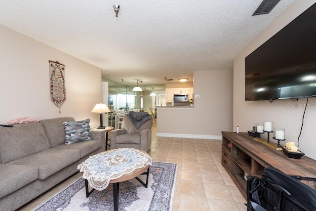 living room with light tile patterned flooring and a textured ceiling