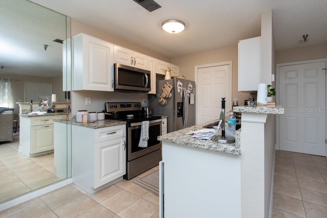 kitchen with kitchen peninsula, white cabinetry, and stainless steel appliances