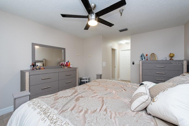 bedroom with ceiling fan and a textured ceiling