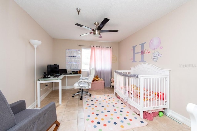 tiled bedroom featuring ceiling fan and a crib