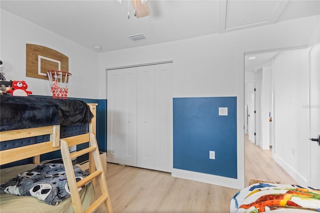 bedroom with light hardwood / wood-style flooring, a closet, and ceiling fan