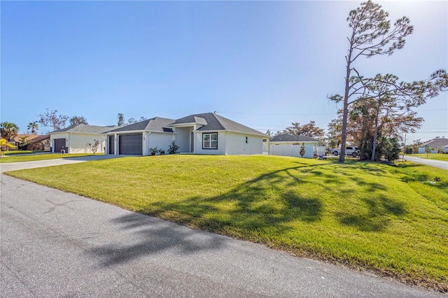 ranch-style house featuring a front lawn and a garage