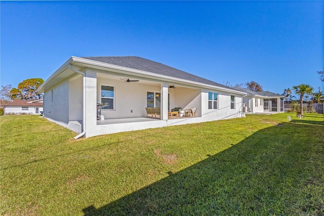 rear view of house featuring a yard, ceiling fan, and a patio area