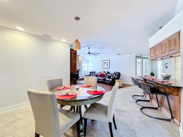 dining room featuring crown molding, light tile patterned floors, and ceiling fan