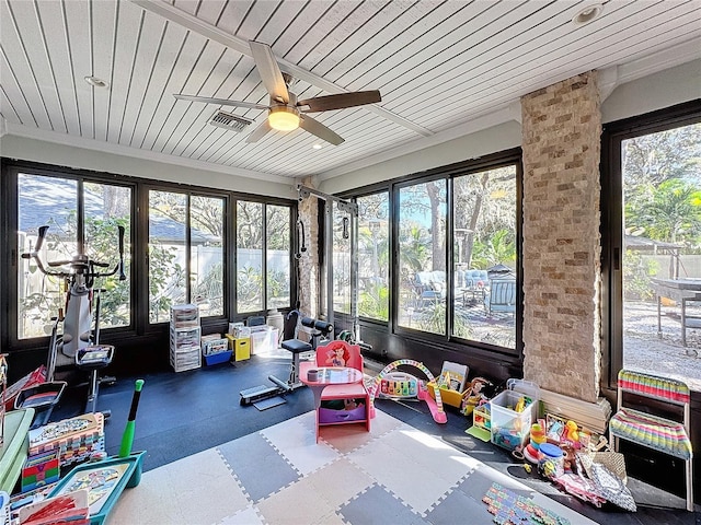 sunroom / solarium featuring plenty of natural light and ceiling fan