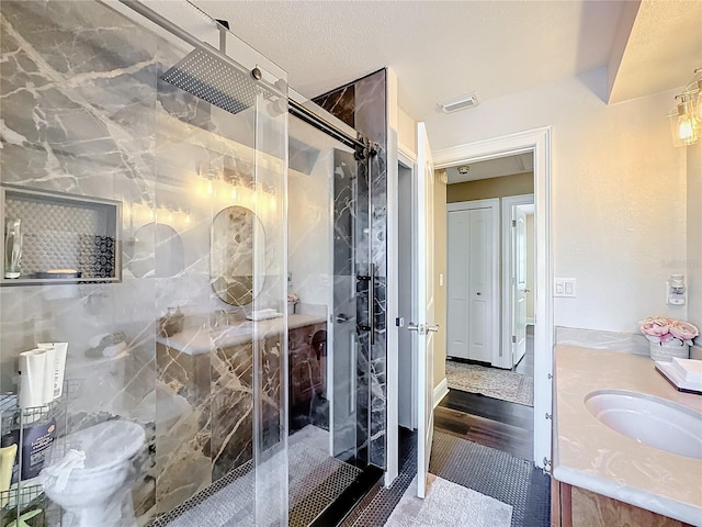 bathroom featuring hardwood / wood-style flooring, vanity, tile walls, a textured ceiling, and an enclosed shower