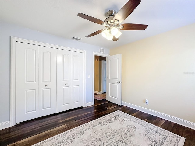 bedroom with dark hardwood / wood-style flooring, a closet, and ceiling fan