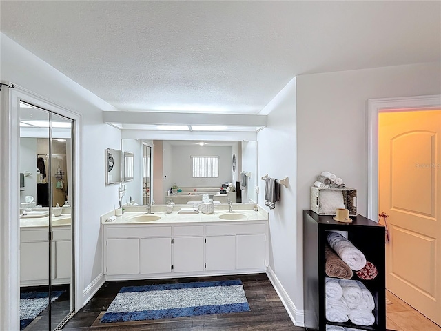 bathroom with vanity, hardwood / wood-style floors, and a textured ceiling