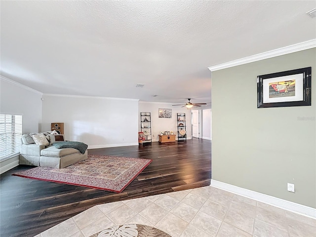 living room with light tile patterned floors, crown molding, a textured ceiling, and ceiling fan