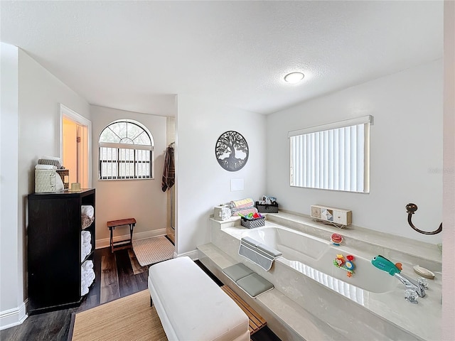 home office with a bath, hardwood / wood-style floors, and a textured ceiling