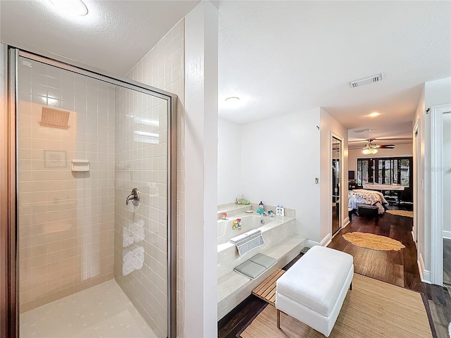 bathroom featuring wood-type flooring, shower with separate bathtub, and ceiling fan