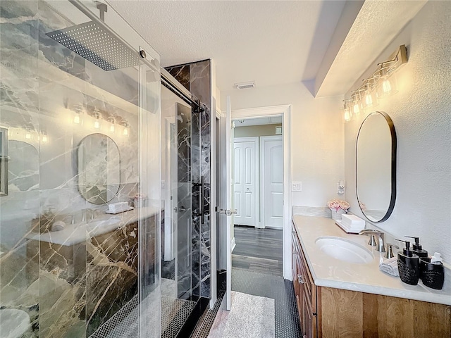 bathroom featuring vanity, a textured ceiling, and walk in shower