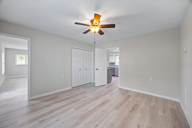 7886 9th Ave S, Saint Petersburg, FL 33707 - unfurnished bedroom with light wood-style floors, baseboards, a closet, and ceiling fan